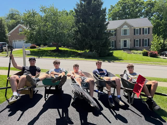 Jacobs Landscaping crew taking a break in their wheelbarrows in a driveway